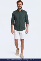 Man wearing white cotton blend Whitecaps * The Everydays men's shorts by Frankster paired with a dark green shirt and beige sneakers, showcasing comfortable and stylish men shorts.
